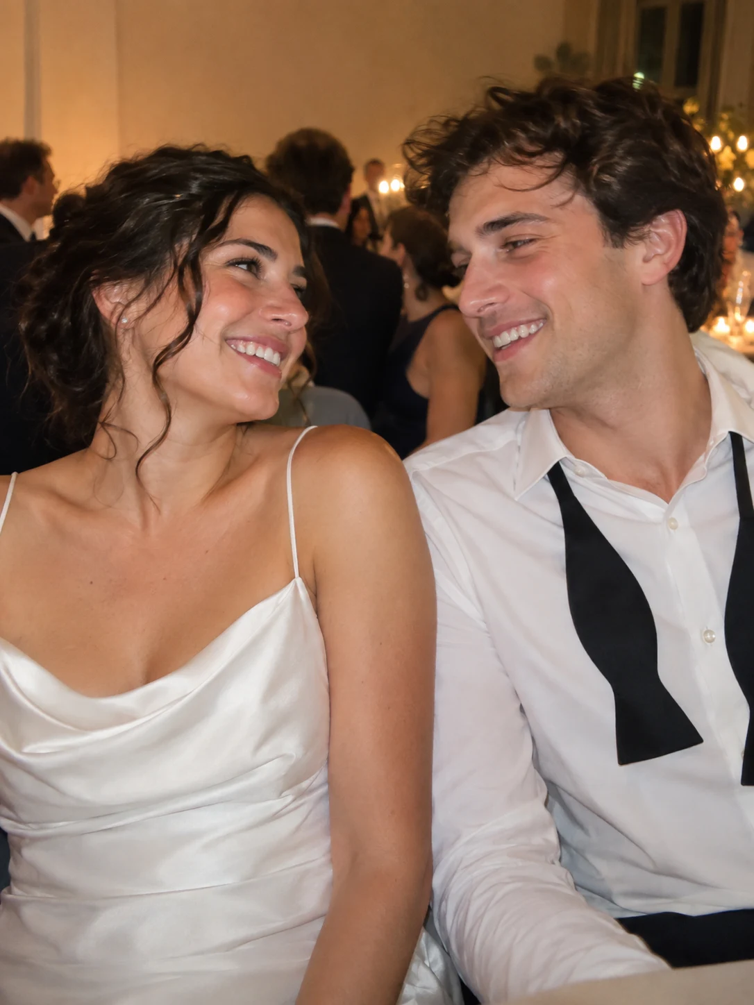 The newlyweds laughing together at their reception table